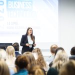 Speaker presenting at the Business and Technology 2026 conference at Kauno kolegija in front of an audience