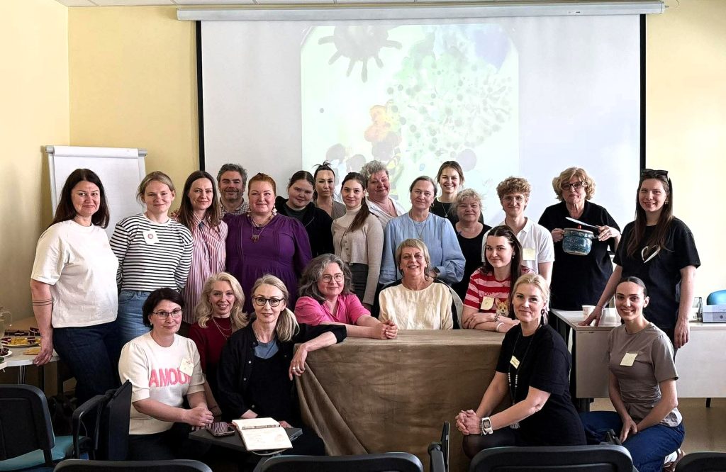 Participants of the international Nordplus project 'Empowering Puppetry' posing together in a classroom after creative workshops and interdisciplinary activities focused on sensory integration and rehabilitation.