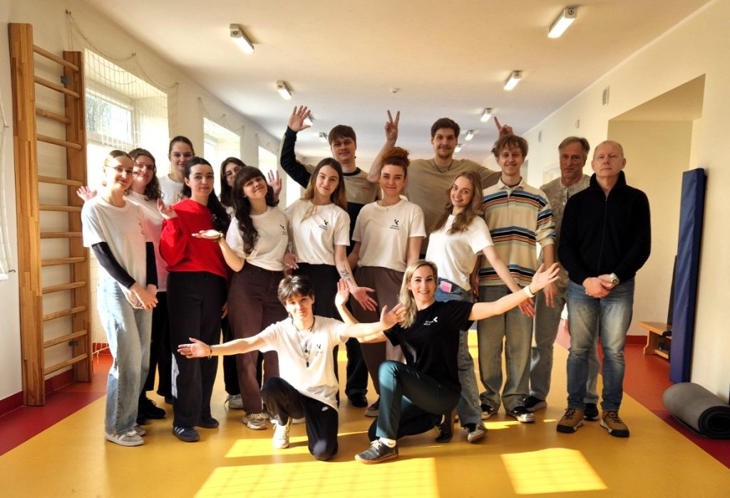 Kauno kolegijos kineziterapijos studentai, dėstytojai ir vaikai po vaikų laikysenos vertinimo įsiamžino bendroje nuotraukoje praktinių veiklų erdvėje.