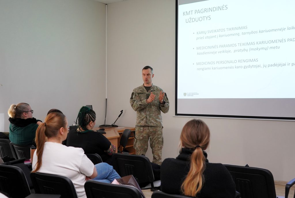 Karo medicinos tarnybos pristatymas Kauno kolegijos Medicinos fakultete – Lietuvos kariuomenės atstovas auditorijoje pristato tarnybos veiklą ir medicinos specialistų vaidmenį slaugos studijų programos studentams.