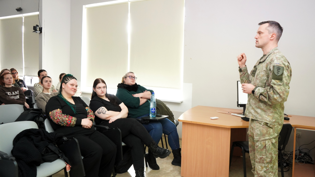 Karo medicinos tarnyba pristatoma Kauno kolegijos Medicinos fakultete – Lietuvos kariuomenės atstovas auditorijoje pasakoja slaugos studijų programos studentams apie medicinos specialistų darbą kariuomenėje.