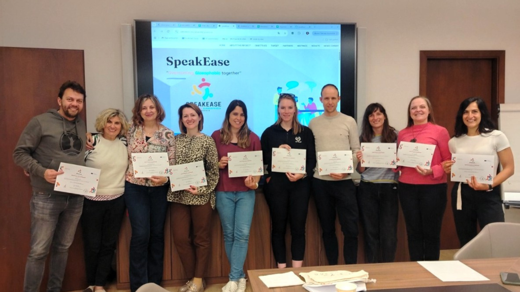 „SpeakEase“ projekto partnerių susitikimo Trente dalyviai su sertifikatais po projekto veiklų aptarimo.