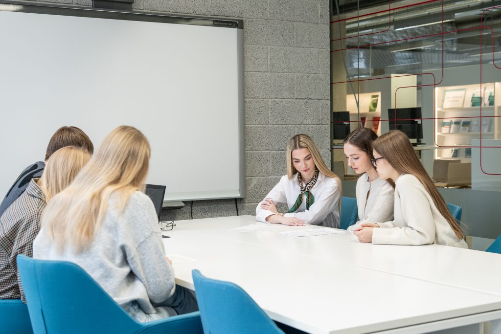 Studentai analizuoja informaciją bibliotekoje